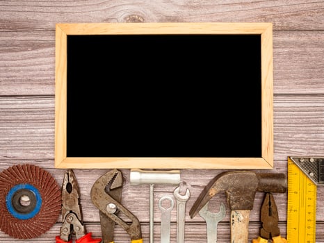 A blank mini chalkboard and construction tools on a wooden table photo