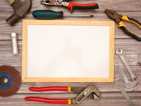 A blank mini whiteboard and construction tools on a wooden table photo
