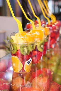 pineapple, kiwi and Strawberries in. plastic container selling at shop photo