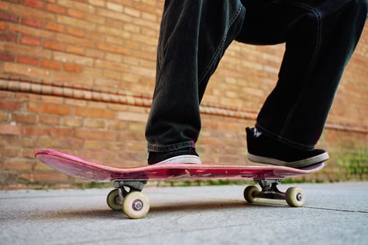 Skateboarder doing trick at urban street. Close up of skater wearing baggy jeans balancing on skateboard. Concept of youth subculture photo