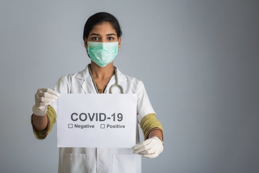 A young woman doctor in a medical mask holding a board of the epidemic of Coronavirus, Covid-19 photo