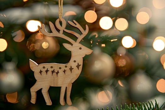 Wooden deer ornament hanging on christmas tree with lights photo