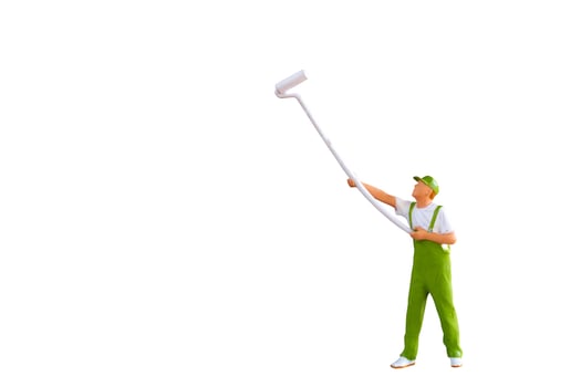 A miniature figurine of a painter holding a long-handled roller brush, isolated on white background with clipping path photo