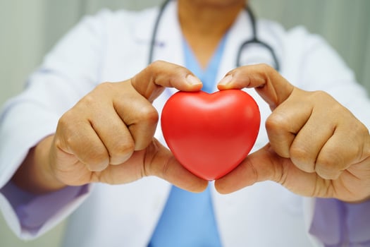 Asian woman doctor holding red heart for health in hospital. photo