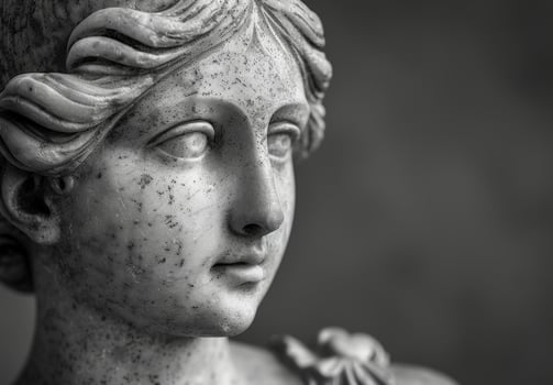 Weathered stone statue face in black and white photo