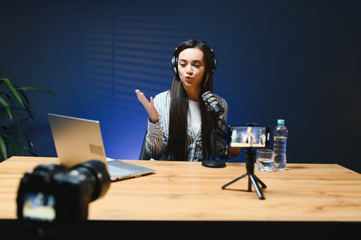 Female vlogger influencer speaking looking at camera, young woman blogger greets fans and talks looking into smartphone, participating in online conference photo