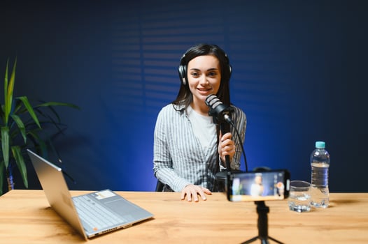 Female vlogger influencer speaking looking at camera, young woman blogger greets fans and talks looking into smartphone, participating in online conference photo