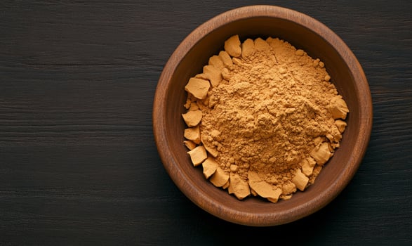 Ginger root and powdered ginger in a bowl, with earthy browns photo