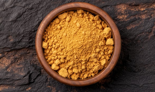Ginger root and powdered ginger in a bowl, with earthy browns and vibrant yellows photo