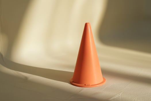 Bright orange traffic cone on a light background photo