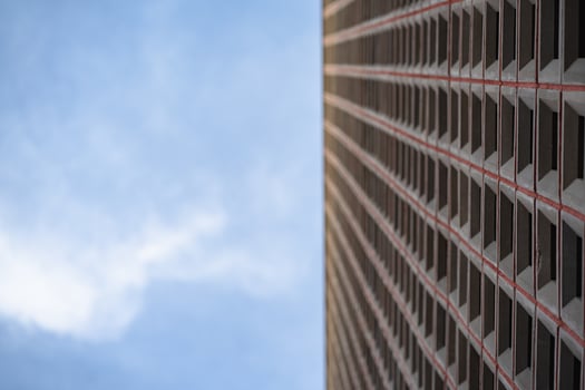 A modern building with a red and black pattern on the facade with blurred blue sky, Close up and selective focus. photo