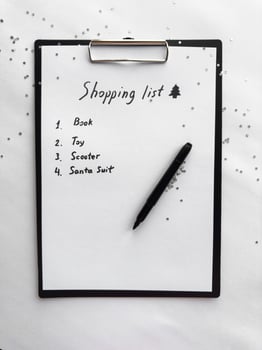 Festive shopping list on clipboard with glitter accent and black marker photo