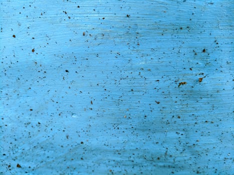 A blue painted wall with some dirt and scratches photo