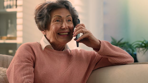 Happy Caucasian old woman carefree middle aged senior lady cheerful smiling retired grandma elderly female granny grandmother talking on smartphone mobile phone talk sharing news on cellphone at home photo