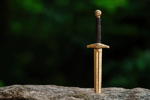 Ornate medieval sword on rocky surface photo