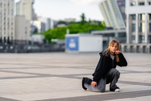 Young dancer practicing movements on urban plaza during daylight hours photo