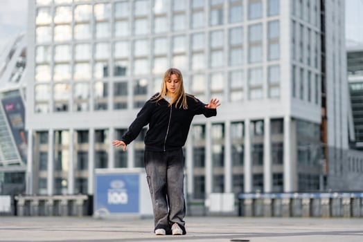 Young dancer performs on an urban plaza during a sunny afternoon in the city photo