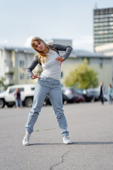 Young dancer showcases street dance moves in urban parking lot during daylight photo