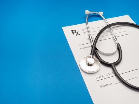 Top view of a stethoscope over the medical prescription sheet on a blue background photo