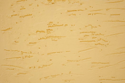 A beautifully textured yellow wall background showcasing subtle striations throughout it photo