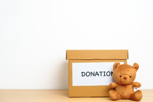 Kid Donation, Charity, Volunteer, Giving and Delivery Concept. Bear doll and Clothes with Donation box at home for support and help poor, refugee and homeless people. Copy space for text photo