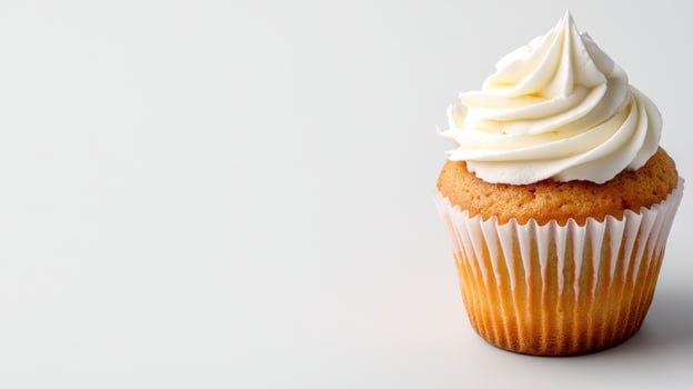 Freshly baked vanilla cupcake topped with creamy frosting photo
