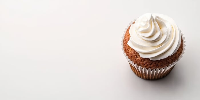 Delicious cupcake topped with creamy frosting on clean background photo