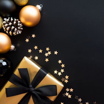 Black and Gold Christmas Arrangement with Gift Box and Baubles on Black Background. Elegant, Festive Christmas Banner, Template, Copy Space, Social Media Post photo
