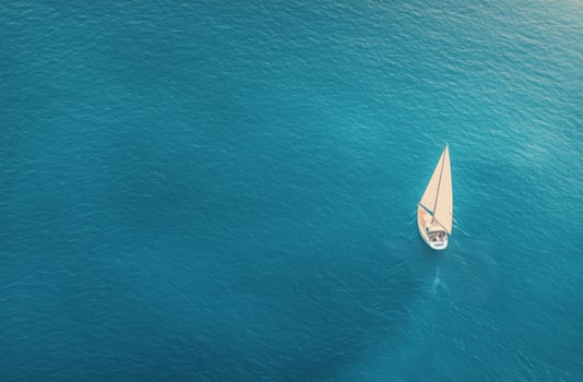 Sailing on calm blue waters with a lone boat under a sunny sky photo