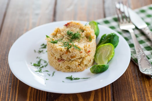 homemade cooked bulgur with Brussel sprouts in a plate, on a wooden table photo