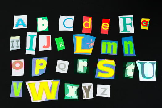 Colorful newspaper alphabet isolated on black photo