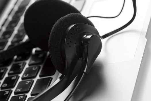 call center support concept. headset on keyboard computer laptop photo