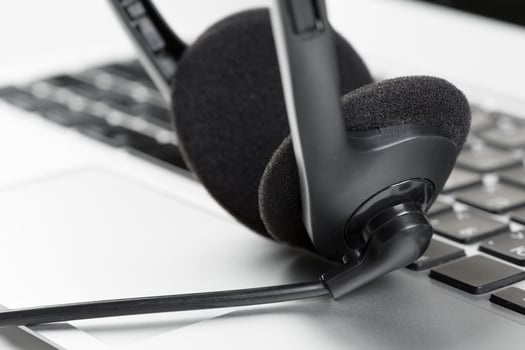 call center support concept. headset on keyboard computer laptop photo