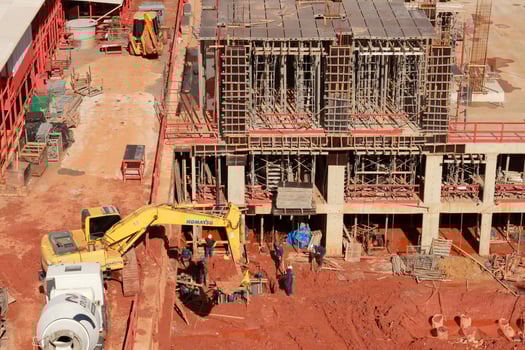 Brasilia, Brazil, November 25 2024 Excavator digging up dirt and putting it in a dump truck during Construction of a New Apartment Building on a rainy day in the 311 block of Noroeste, Brasilia photo