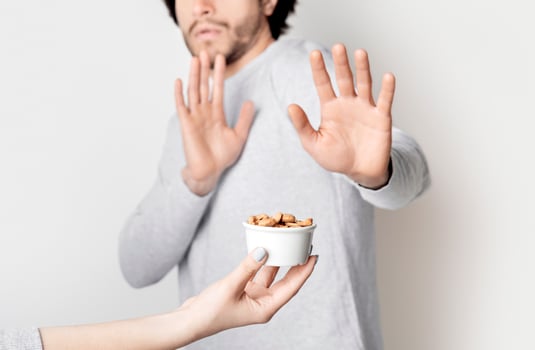 Food allergy concept. Man is afraid of nuts, cropped photo