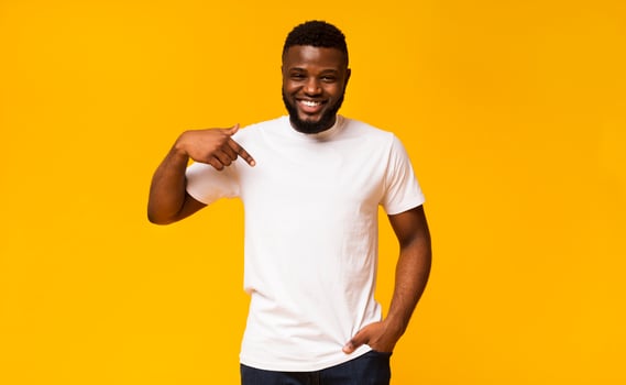 Look at my new t-shirt. Young black man pointing at blank space of his clothes photo