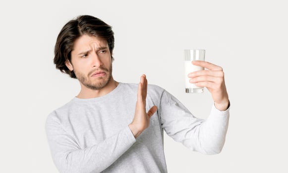 Allergy on lactose concept. Man refuses milk, free space photo