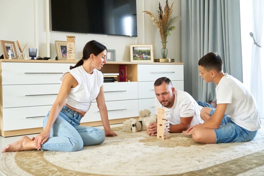 Family playing a tower building game together in a cozy living room during the afternoon photo