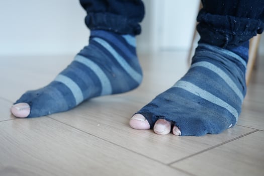 Close-Up of Worn Out Striped Socks on Wooden Floor photo