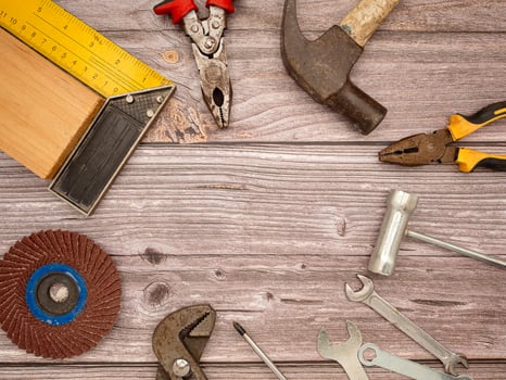 Construction tools, a hammer, screwdriver, screws, and pliers on a wooden table photo