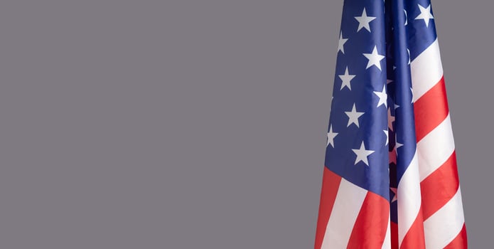 The American flag is on the right side on a gray background photo