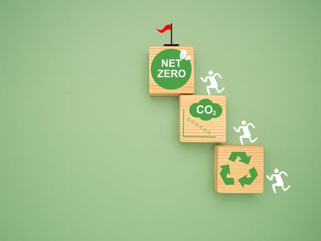 Net-zero greenhouse gas emissions target. Wooden cubes with CO2 green icons over a green background. photo