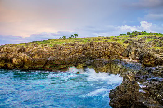 A view of the waves at the edge of the cliffs during sunset at Kelapa Satu Beach in Kupang, East Nusa Tenggara photo