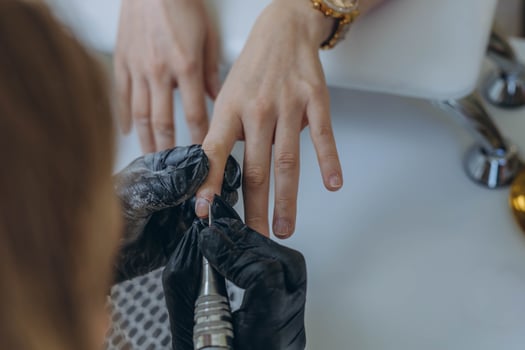Manicure master, working in the beauty salon shaping the nails of a young female client photo