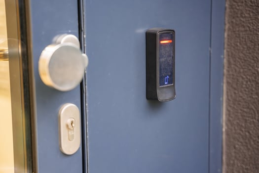 Close up view of door with electric lock with reader of entry system mounted on a house wall. High quality photo