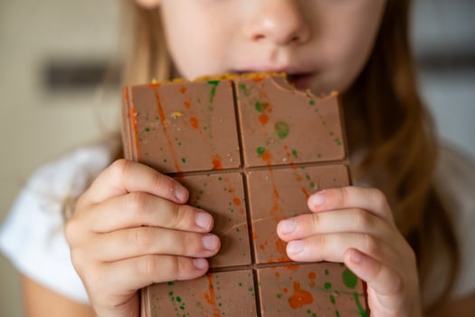 Dubai chocolate with pistachio paste and kataifi dough in hands of little girl. Confectionery handmade sweets at home in the kitchen. High quality photo