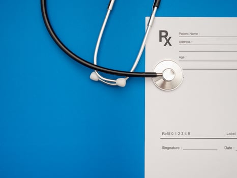 Top view of a stethoscope over the medical prescription sheet on a blue background photo