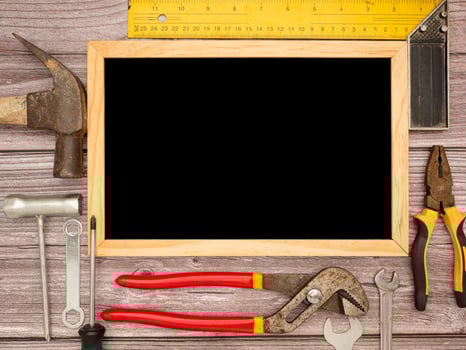 A blank mini chalkboard and construction tools on a wooden table photo