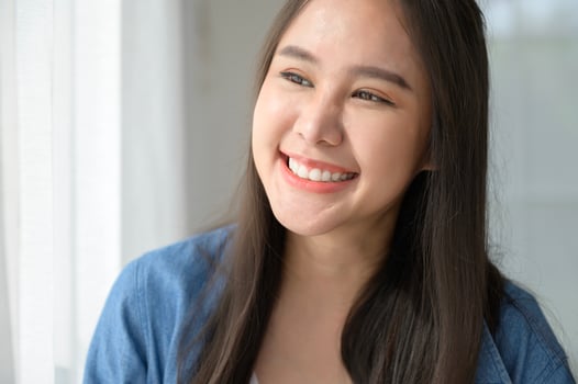 Close up a young asian woman face smiling at home photo