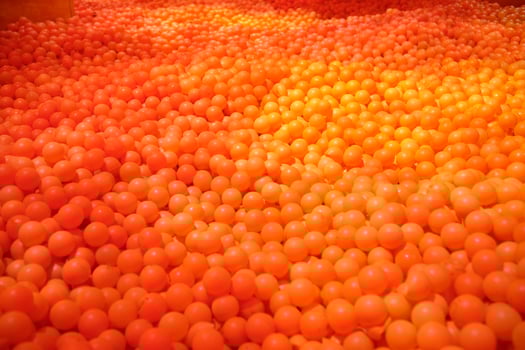 Huge ball pit with orange plastic balls photo